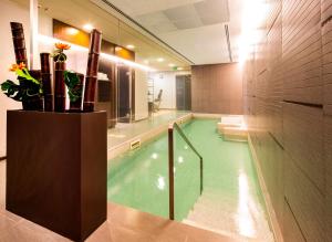 纳维廖河畔特雷扎诺贝斯特韦斯特黄金蜜雷酒店的一个带大型游泳池的浴室