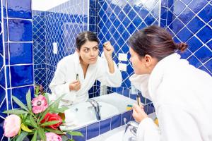 萨萨里马里尼酒店的把牙齿刷在浴室镜子前的女人
