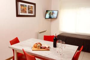 布兰卡港Este Apart的一张桌子,上面放着一瓶葡萄酒、面包和酒杯