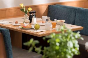 汉诺威Ramada by Wyndham Hannover的一张木桌,上面摆放着早餐食品和饮料