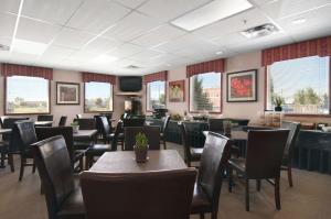 Stony Plain斯托尼平原汽车旅馆的用餐室设有桌椅和窗户。