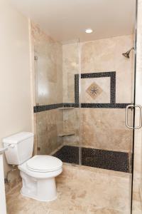 圣克鲁兹海滩街套房酒店的一间带卫生间和玻璃淋浴间的浴室