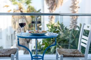 卡马利阿拉斯汉姆海滩酒店的一张桌子,上面放着一盘食物和一杯葡萄酒