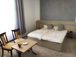 捷克捷欣Hotel Piast的酒店客房带一张床、一张桌子和椅子