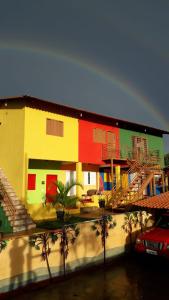 戈亚斯州上帕莱索Atelier & Pousada Chapada的一座五彩缤纷的房屋,前面有棕榈树