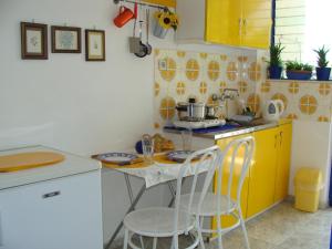 阿吉亚玛丽娜Helios Hotel的一间带桌子和黄色橱柜的小厨房