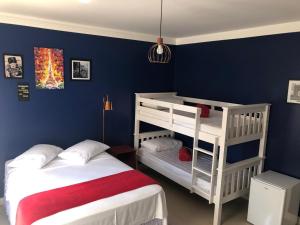 佩尼亚Mundo Livre Guest House的一间卧室设有两张双层床,拥有蓝色的墙壁。