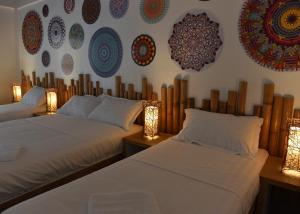圣维森特Lazuli Resort的墙上挂有盘子的房间的两张床
