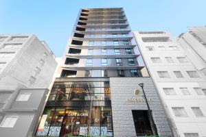 东京Quintessa Hotel Tokyo Ginza的前面有一间商店的高楼