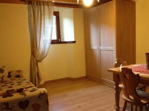 菲乌马尔博阿尔卑斯萨拉农家乐的客房设有桌子、椅子和窗户。