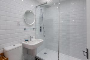 伦敦GuestReady - 1BR Flat Ideally Located In Zone 2 Fits 3的白色的浴室设有水槽和淋浴。