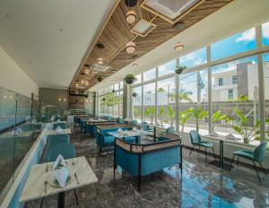 佩雷贝勒Ocean V Hotel的餐厅设有蓝色的椅子和桌子以及窗户。