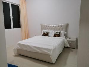 瓜埠Cozy 3 Bedrooms Apartment Langkawi的白色卧室配有白色床和2个枕头
