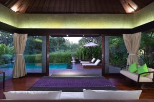 苏卡瓦提Sanctoo Suites & Villas的一间带床和游泳池的客厅