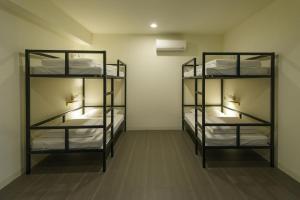 嘉义市客旅家青年旅館 Travelers Plus的一间设有三张双层床的客房