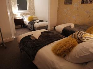 曼彻斯特Corner House, Sleeps 8 in 4 Bedrooms, near train station, Great Value!的酒店客房设有三张床和一张书桌