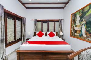 本托塔Lucas的一间卧室配有一张带红色枕头的大床