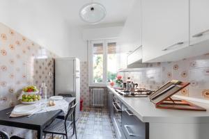 费拉拉Casa Sibilla的白色的厨房配有桌子和冰箱