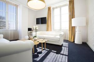 奥尔良印记Spa酒店的客厅配有白色的沙发和桌子