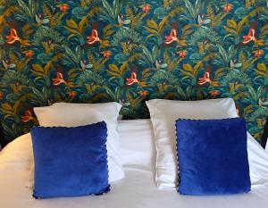 蓬托尔松蒙特住宿加早餐旅馆的花卉壁纸前的一张带两个枕头的床