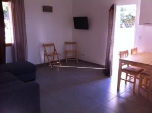Barbaggio卡萨安德里亚酒店的客厅配有沙发和桌椅