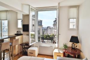 巴黎蒙马特公寓的客厅设有桌子和大窗户