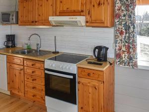 AukraHoliday home Aukra III的厨房配有木制橱柜和炉灶烤箱。