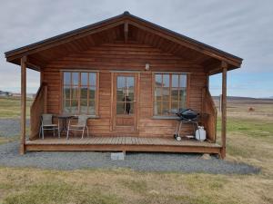 Stöng斯通小屋旅馆的木屋在田野里配有桌椅