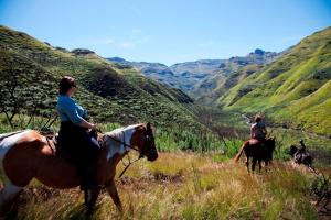 Butha-Buthe马利巴河山林小屋的两个人在草地上骑马
