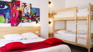 朗戈涅hotel le beauséjour的客房内的2张双层床和红色枕头