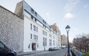 巴黎巴黎蒙马特城市奥德利公寓式酒店的街道边的白色建筑