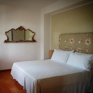 拉斯卡里Terre e Torri Country Resort的卧室配有白色床和墙上的镜子