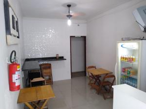 阿帕雷西达Pousada Vitória的厨房配有冰箱和桌椅