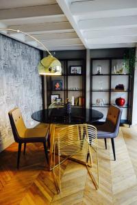 兰斯Loft Royal des Promenades的一间设有玻璃桌和两把椅子的用餐室