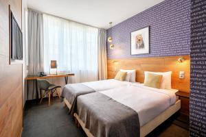 布达佩斯布达佩斯中心鲁姆拜酒店的酒店客房设有一张大床和一张书桌。
