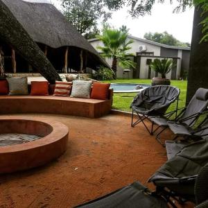 奥卡汉贾AFRICAN DREAMS GUESTHOUSE的一个带沙发和椅子的庭院和一个游泳池