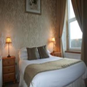 格文罗耶尔酒店的一间卧室配有一张带两盏灯的床和一扇窗户。