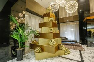 丹吉尔市中心皇家金色郁金香酒店的大堂的金色螺旋楼梯,有棕榈树