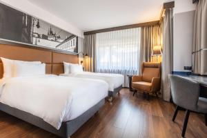 布拉格Radisson Blu Hotel Prague的酒店客房配有两张床和一张书桌
