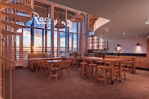 赫尔辛基赫尔辛基丽笙海滨酒店的餐厅设有桌椅和大窗户。