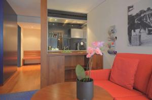 圣加仑圣加仑丽笙酒店的客厅配有红色的沙发和桌子