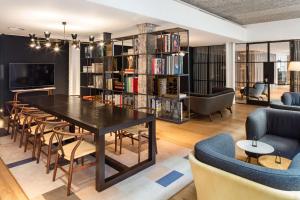 伦敦Radisson Blu Mercer Street Hotel, London的一间带桌椅的客厅和一个图书馆