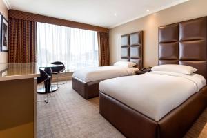 希灵登Radisson Blu Edwardian Heathrow Hotel, London的酒店客房配有两张床和一张书桌
