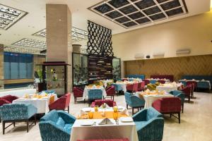 加济阿巴德萨希巴巴德丽怡酒店及套房的用餐室配有桌椅