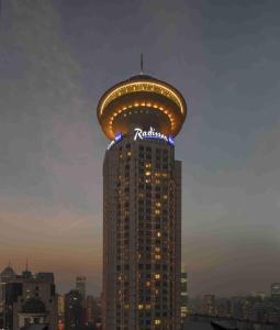 上海上海新世界丽笙大酒店的一座高大的建筑,上面有标志