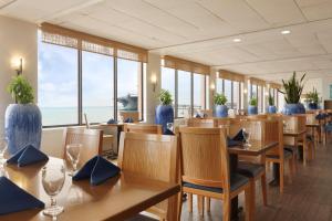 科珀斯克里斯蒂DoubleTree by Hilton Corpus Christi Beachfront的一间设有木桌和椅子的餐厅,享有海景