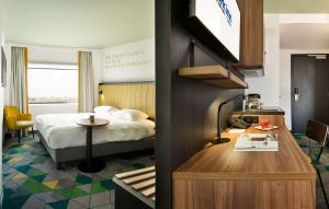 哈瑟尔特哈瑟尔特雷迪森公园酒店的一间酒店客房,配有一张床和一张书桌