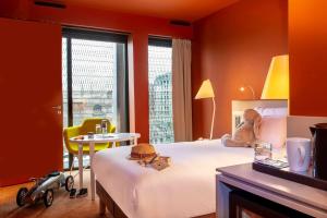 波尔多Radisson Blu Hotel Bordeaux的卧室配有1张床、1张桌子和1把椅子