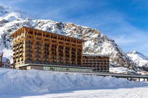 安德马特Radisson Blu Hotel Reussen, Andermatt的雪覆盖的山前的建筑物