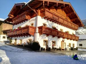 蓬高圣约翰Urlaub am Bauernhof Rothof的一座大建筑,设有雪地木制阳台